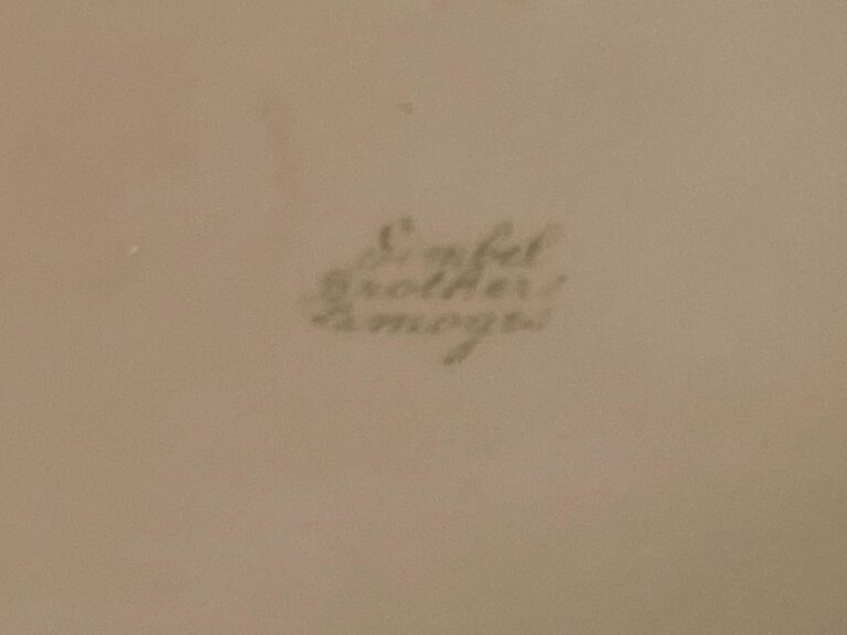 Small, handwritten text on a beige background, difficult to read due to blurriness.