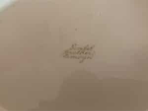 Faded text reading "Dimbel Brothers Limoges" on a beige surface.