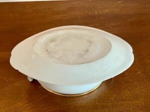 White ceramic casserole dish with lid on a wooden table.