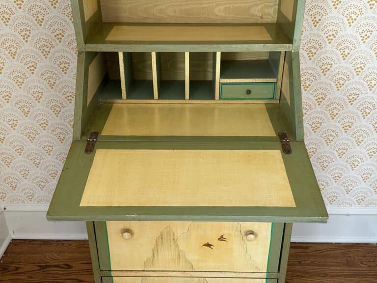 Vintage wooden secretary desk with fold-out writing surface, small cubbyholes, drawer, and bird motif on the front.