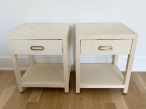 Two matching light wood nightstands with drawers and lower shelves, placed side by side on a wooden floor.