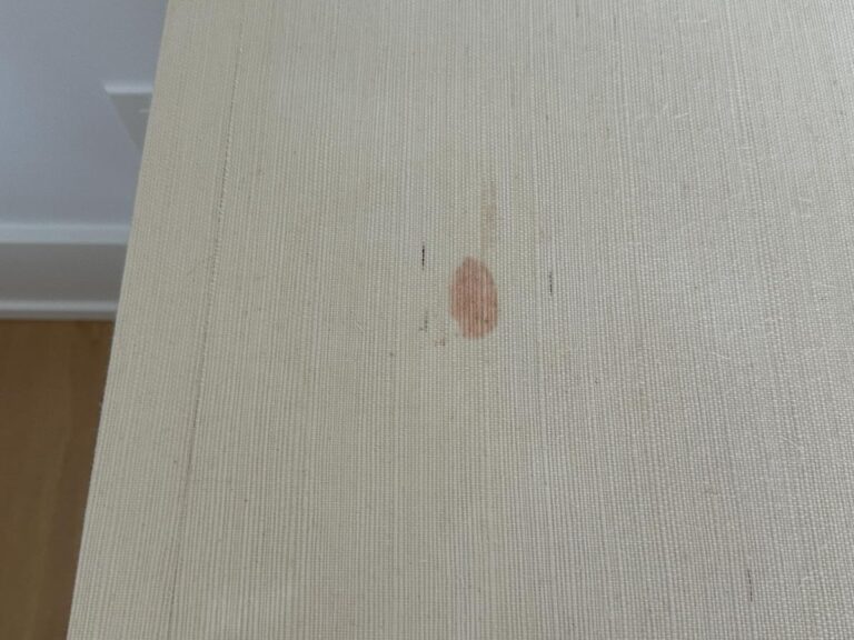 A beige textured tabletop with a visible brownish stain near the center.