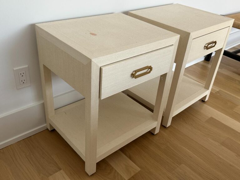 Two light-colored wooden nightstands with drawers and brass handles, placed side by side on a wood floor.