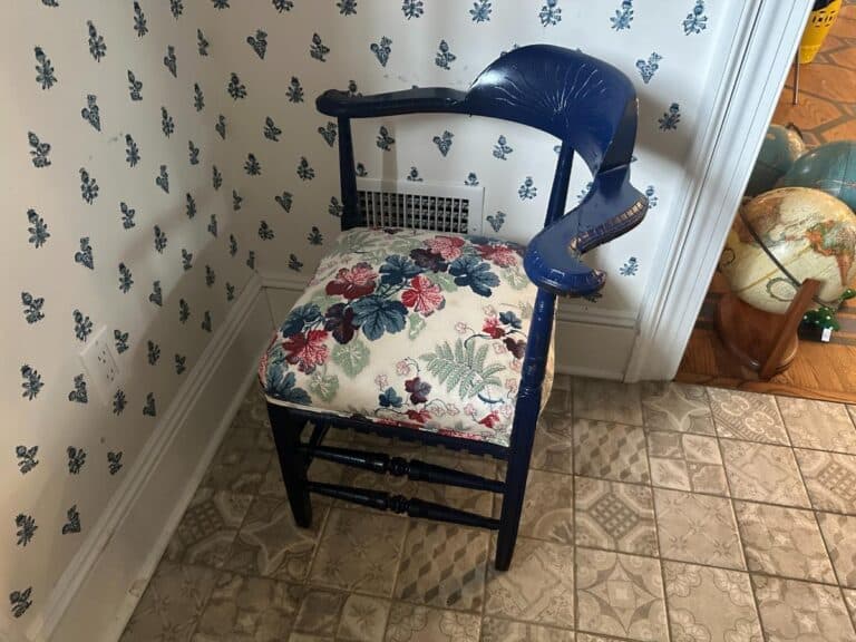 Blue Painted Corner Chair with Cowtan & Tout Seat in a room featuring patterned wallpaper and a tiled floor.