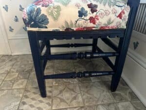 A Blue Painted Corner Chair with a Cowtan & Tout seat sits on a patterned tile floor.