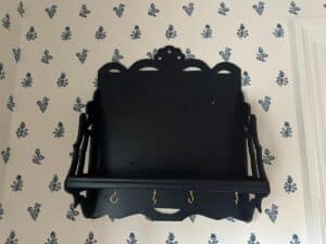Blue Wall Shelf / Bracket with hooks on wallpaper featuring blue floral motifs.