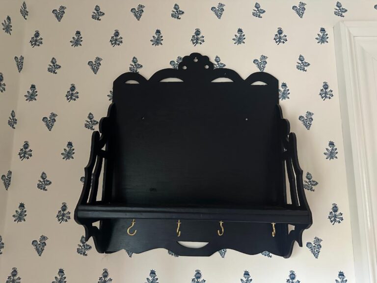 Blue Wall Shelf / Bracket with hooks on wallpaper featuring blue floral motifs.