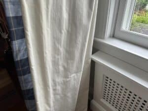 Close-up of Blue Stripe Panels, Set of 6, featuring light and dark stripes next to a white window frame with a hint of greenery beyond.
