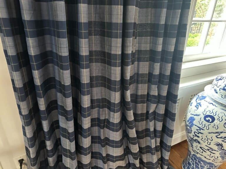 Blue stripe panels, set of 6, hang beside a decorative blue and white vase by a window.