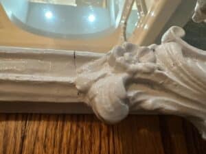 Close-up of the Vintage Chinoiserie Mirror featuring a decorative white corner molding with floral details.