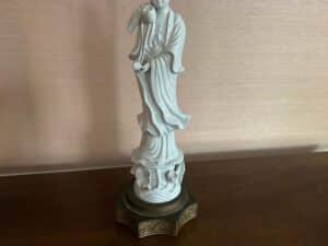 Porcelain Blanc De Chine Figural Lamp set featuring robed figures on decorative bases, set against a soft pink background.