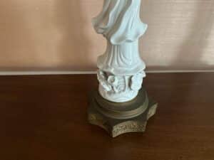 Pair of Blanc De Chine Figural Lamps featuring white figurines atop a decorative brown stand on a wooden surface.