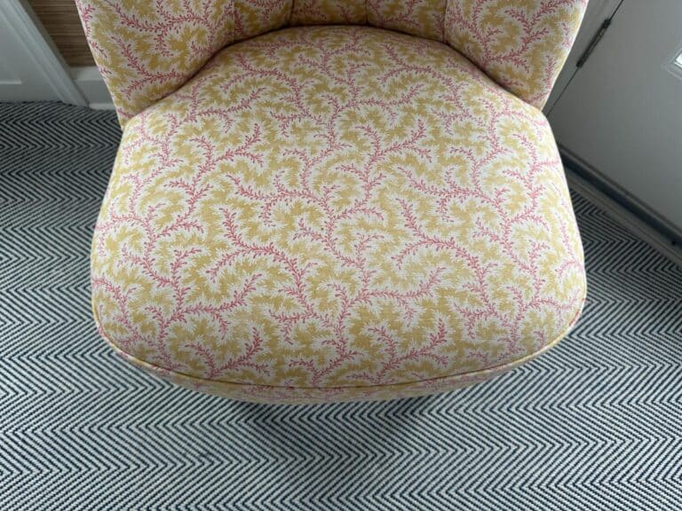 Petite Tufted Back Side Chair on Casters with ornate pink and yellow floral design sits on a black-and-white zigzag pattern carpet.