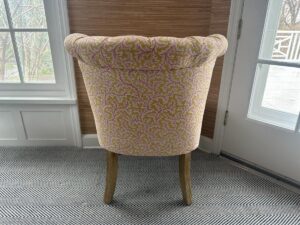 The Petite Tufted Back Side Chair on Casters with a floral pattern is featured in a bright room with large windows and a herringbone carpet.