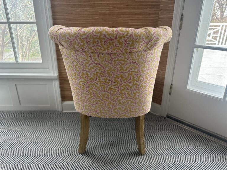 The Petite Tufted Back Side Chair on Casters with a floral pattern is featured in a bright room with large windows and a herringbone carpet.