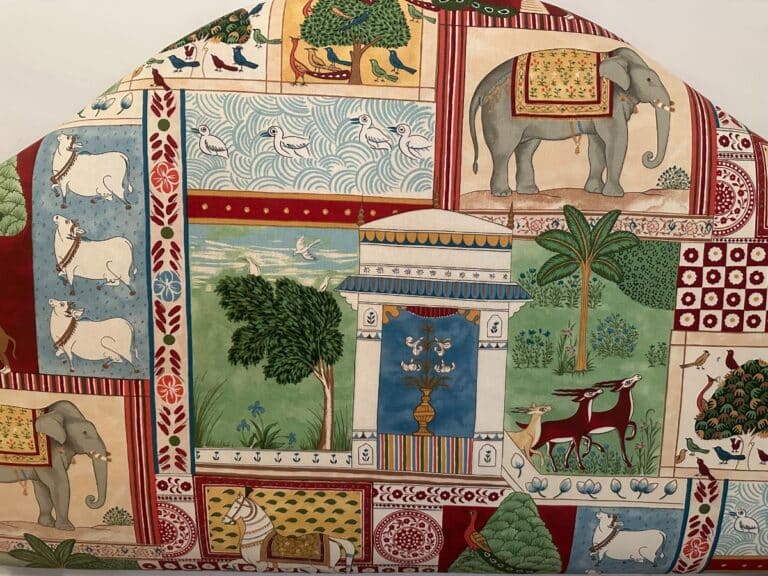 Jane Churchill for Cowtan & Tout's Indian Summer Full Size Headboard showcases elephants, trees, and decorative motifs in a patchwork design featuring various animals and patterns.