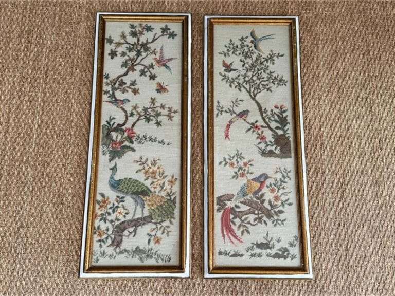Two pieces of vintage framed needlepoint artwork featuring embroidered birds and trees on a woven background.