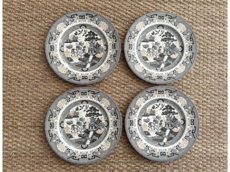 A set of four ornate black and gold Staffordshire plates with intricate designs.