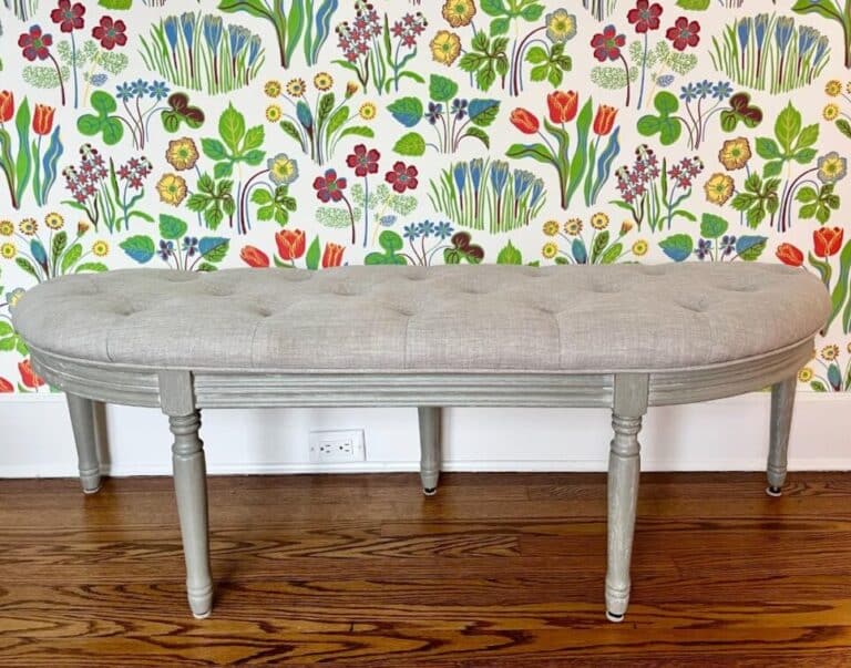Demilune Tufted Bench set against vibrant floral wallpaper with a wooden floor.