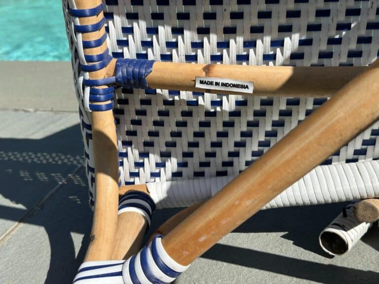 Woven chair by a pool, labeled "Made in Indonesia," with blue and white details.