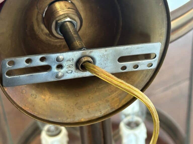 Close-up of a lamp base with exposed wiring and a metal mounting bracket.