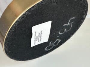 A round object with a black surface, a white label, and “43.50” written in white marker.